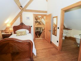 A bedroom with a bed and a doorway to a bathroom at Rookery Hall Middle Hill near Broadway