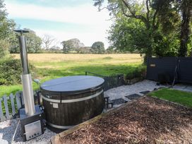 A garden with a hot tub and wood stove at Wood Brook Cottage in Crowan