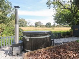 An outdoor hot tub with a chimney at Wood Brook Cottage in Crowan