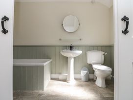 A bathroom with a bathtub sink toilet and a small trash bin at Beaconsfield Cottage Burniston near Scalby