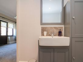 A bathroom sink with grey cabinetry and a mirror above at Beaconsfield Cottage in Burniston near Scalby