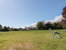 A grassy outdoor area with a small soccer goal and two balls near houses and trees at Beaconsfield Cottage in Burniston near Scalby