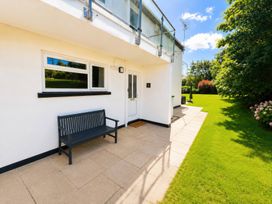 An outdoor area with a bench and door at 6 Coedrath Park - Swn y Mor, Saundersfoot