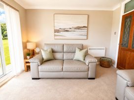 A living room with a sofa and a side table at 6 Coedrath Park - Swn y Mor in Saundersfoot