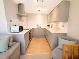 A kitchen with appliances and cabinets at 6 Coedrath Park - Swn y Mor, Saundersfoot