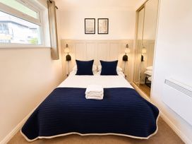 A bedroom with a bed and wall art at 6 Coedrath Park - Swn y Mor Saundersfoot