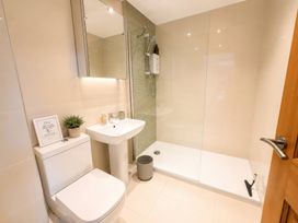 A bathroom with a shower, sink, and toilet at 6 Coedrath Park - Swn y Mor in Saundersfoot