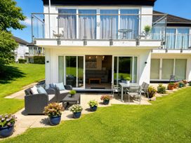 An outdoor patio with seating and plants at 6 Coedrath Park - Swn y Mor in Saundersfoot