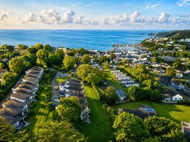 A view of houses and the sea with boats at 6 Coedrath Park - Swn y Mor Saundersfoot
