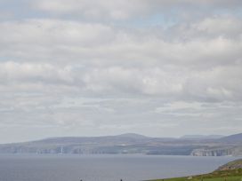 A coastal landscape with cliffs hills and the ocean at The Cabin in Occumster near Lybster