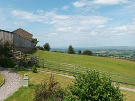 A house and field with trees and a fence at The Journeyman Luxury Shepherds Hut Barnoldswick