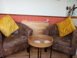 Two armchairs and a coffee table in a living room at The Journeyman Luxury Shepherds Hut Barnoldswick