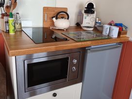 A kitchen with a microwave and kettle at The Journeyman Luxury Shepherds Hut Barnoldswick