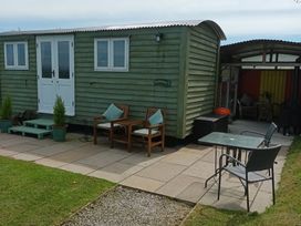 An outdoor area with a shepherd's hut and seating at The Journeyman Luxury Shepherds Hut in Barnoldswick