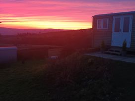 A sunset view featuring a cabin and landscape at The Journeyman Luxury Shepherds Hut in Barnoldswick