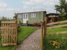 A shepherd's hut with a pathway and gate at The Journeyman Luxury Shepherds Hut in Barnoldswick