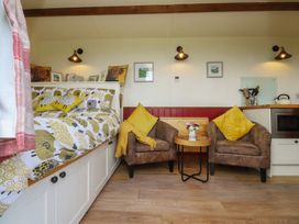 A living room with a bed and armchairs at The Journeyman Luxury Shepherds Hut Barnoldswick
