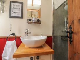 A bathroom with a wash basin and shower at The Journeyman Luxury Shepherds Hut Barnoldswick