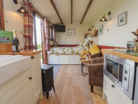 A living area with a bed and sofa at The Journeyman Luxury Shepherds Hut in Barnoldswick