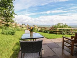 An outdoor area with a table and chairs at The Journeyman Luxury Shepherds Hut in Barnoldswick
