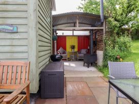 An outdoor seating area with chairs and a table at The Journeyman Luxury Shepherds Hut in Barnoldswick
