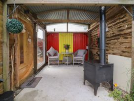 A snug area with seating and a stove at The Journeyman Luxury Shepherds Hut in Barnoldswick