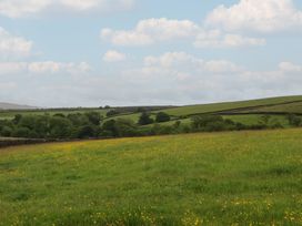 A field with flowers and trees on hills at The Journeyman Luxury Shepherds Hut Barnoldswick