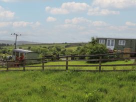 An outdoor view with buildings, grass, and trees at The Journeyman Luxury Shepherds Hut Barnoldswick