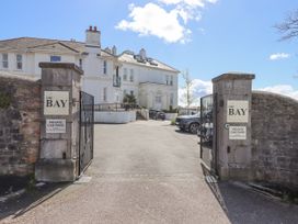 The open gates at the entrance to a private car park with a white building and parked cars at The Bay in Torquay