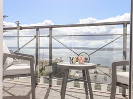 A balcony with two chairs and a small round table with two mugs overlooking the sea at Bay Sea View in Torquay