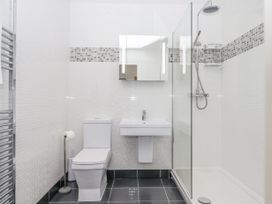 A bathroom with a toilet sink glass shower enclosure and a wall mirror at Bay Sea View in Torquay