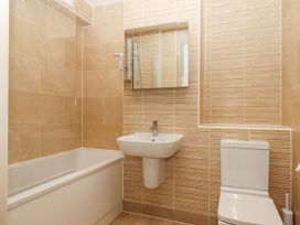 A bathroom with a bathtub a sink a toilet and a mirror at Bay Sea View Torquay