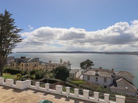 A view of a coastal area with houses and trees overlooking the sea at Bay Sea View in Torquay