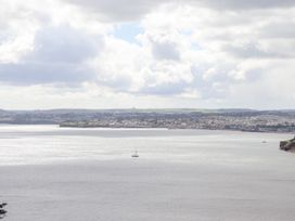 A body of water with a sailboat and a town with houses in the background at Bay Sea View in Torquay