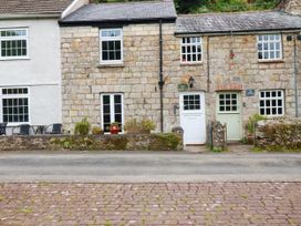 A row of houses with stone walls and planters at Vi’s Valley View in Pentewan