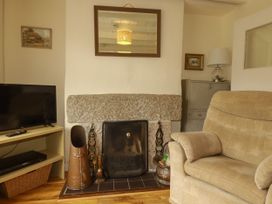 A living room with a fireplace and a television at Vi’s Valley View, Pentewan