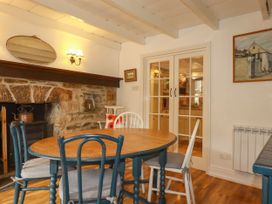 A dining room with a table and chairs at Vi’s Valley View Pentewan