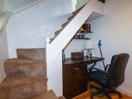 A home office area with desk and chair under the stairs at Vi’s Valley View in Pentewan