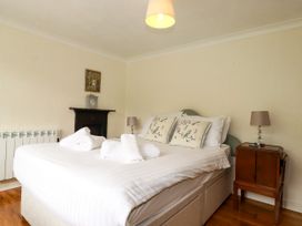 A bedroom with a bed and nightstand at Vi’s Valley View in Pentewan