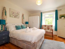 A bedroom with a bed and chair at Vi’s Valley View, Pentewan