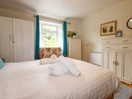 A bedroom with a bed and wardrobe at Vi’s Valley View in Pentewan