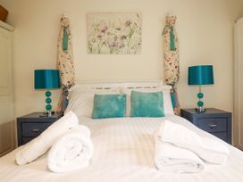 A bedroom with a bed and blue lamps at Vi’s Valley View in Pentewan