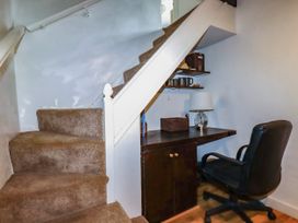 A home office area with a desk and chair under the staircase at Vi’s Valley View Pentewan