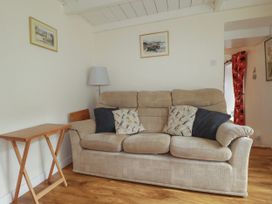 A living room with a sofa and a side table at Vi’s Valley View Pentewan