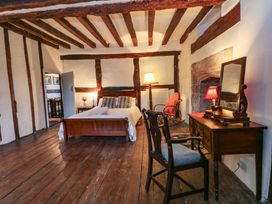 A bedroom with a bed and a desk at Y Fferm in Pontblyddyn