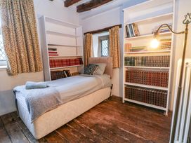A bedroom with a bed and bookshelves at Y Fferm in Pontblyddyn