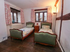 A bedroom with two beds and a nightstand at Y Fferm in Pontblyddyn