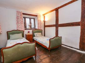 A bedroom with two single beds and a bedside table at Y Fferm in Pontblyddyn