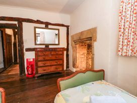 A bedroom with a bed and fireplace at Y Fferm in Pontblyddyn