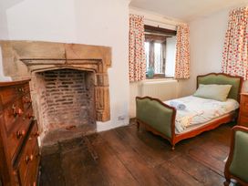 A bedroom with a bed and fireplace at Y Fferm in Pontblyddyn